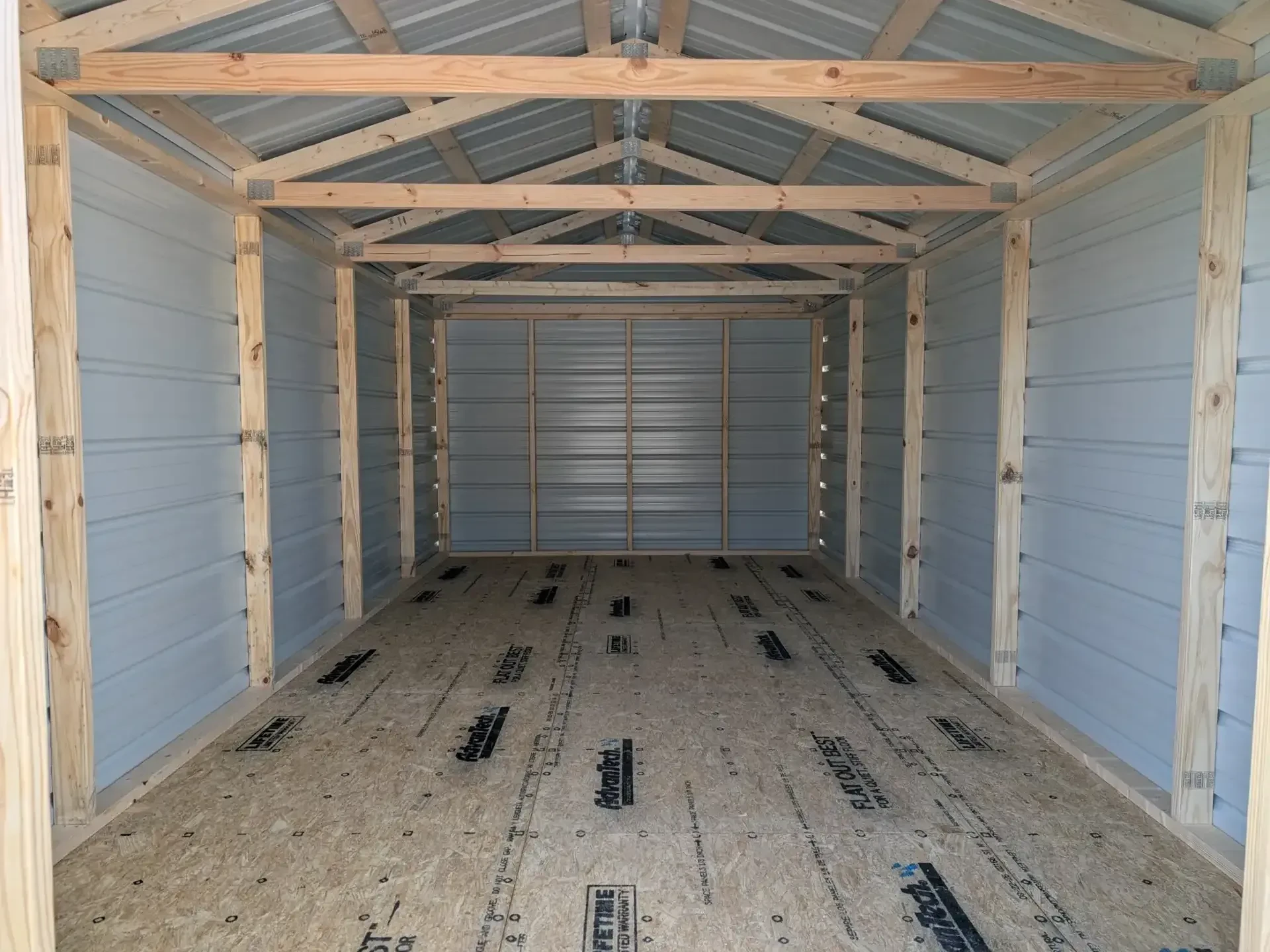 the inside of a metal utility shed. You can see the inside of the metal and the wood framing