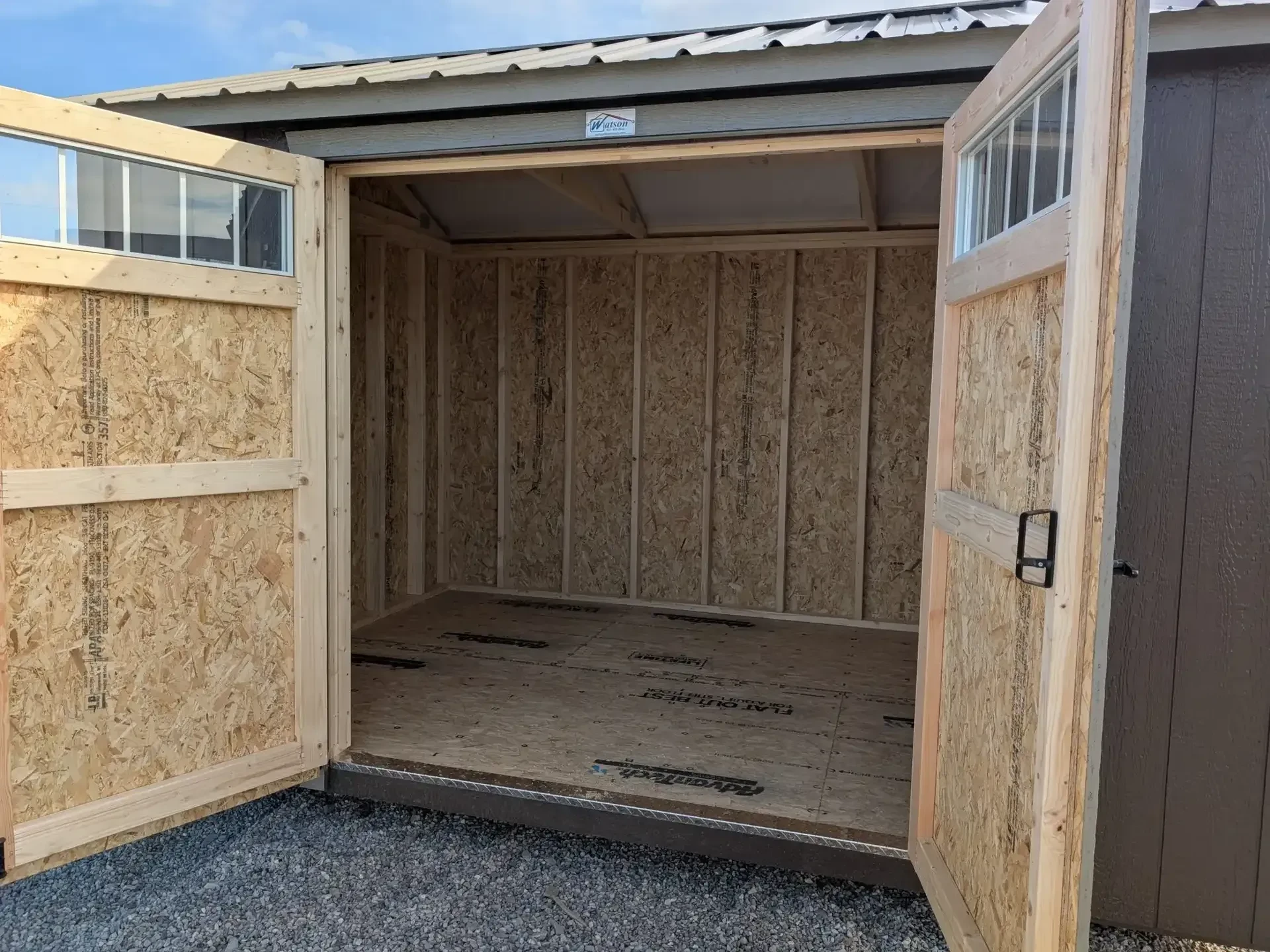 looking through open double doors into a wood garden shed