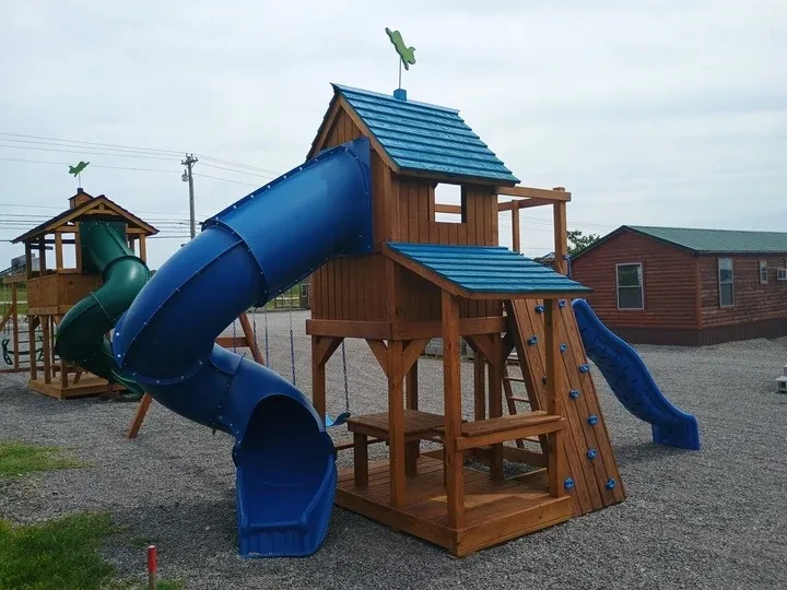 Wood playset with blue turbo slide and accents and a cute lemonade stand attached.