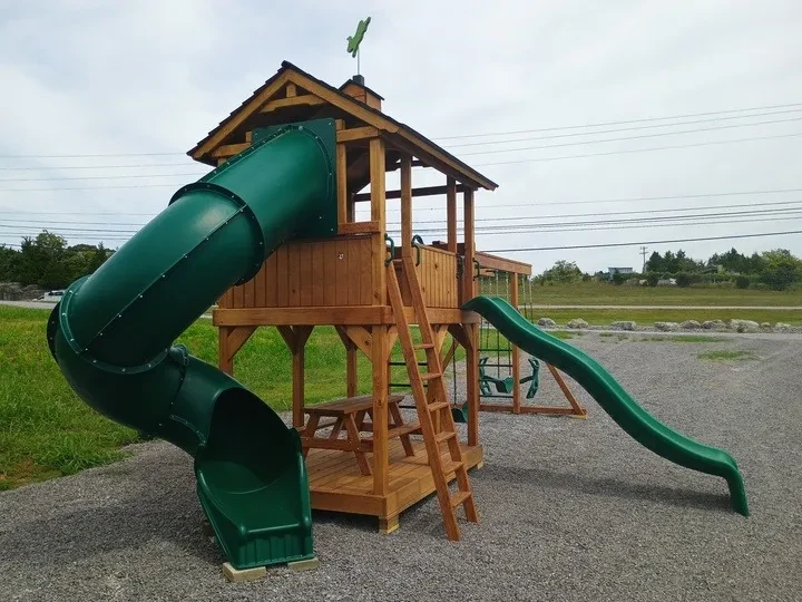 Deluxe fort playset with green slides and a picnic table