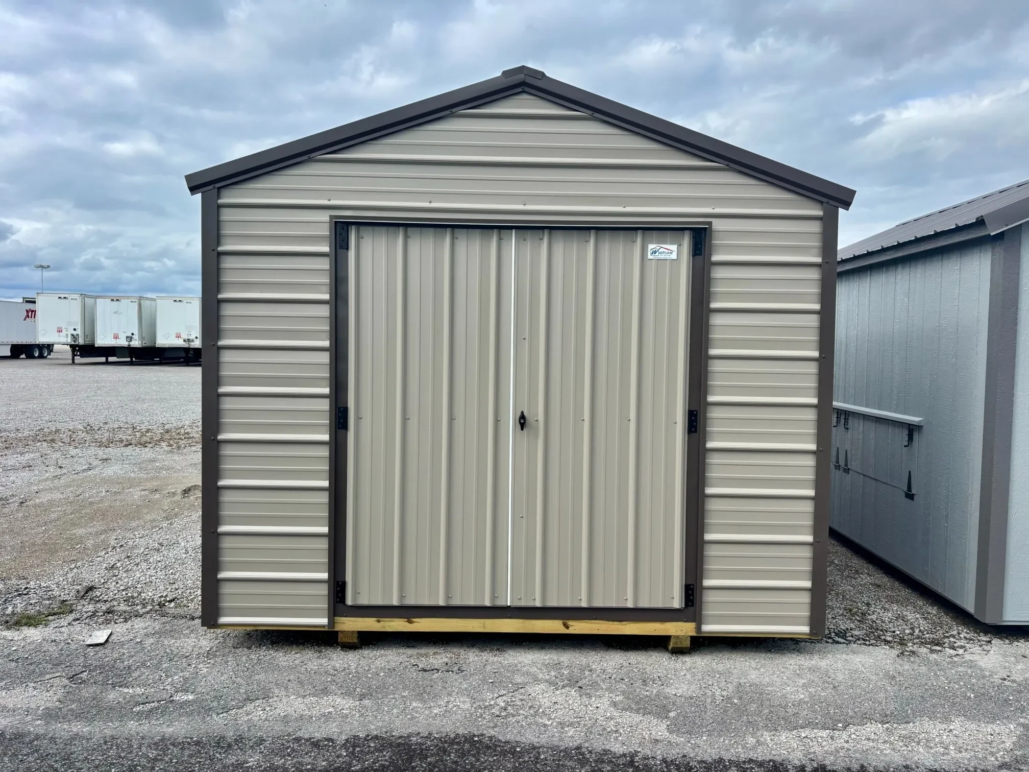 A bronze metal shed outside with bronze colored trim