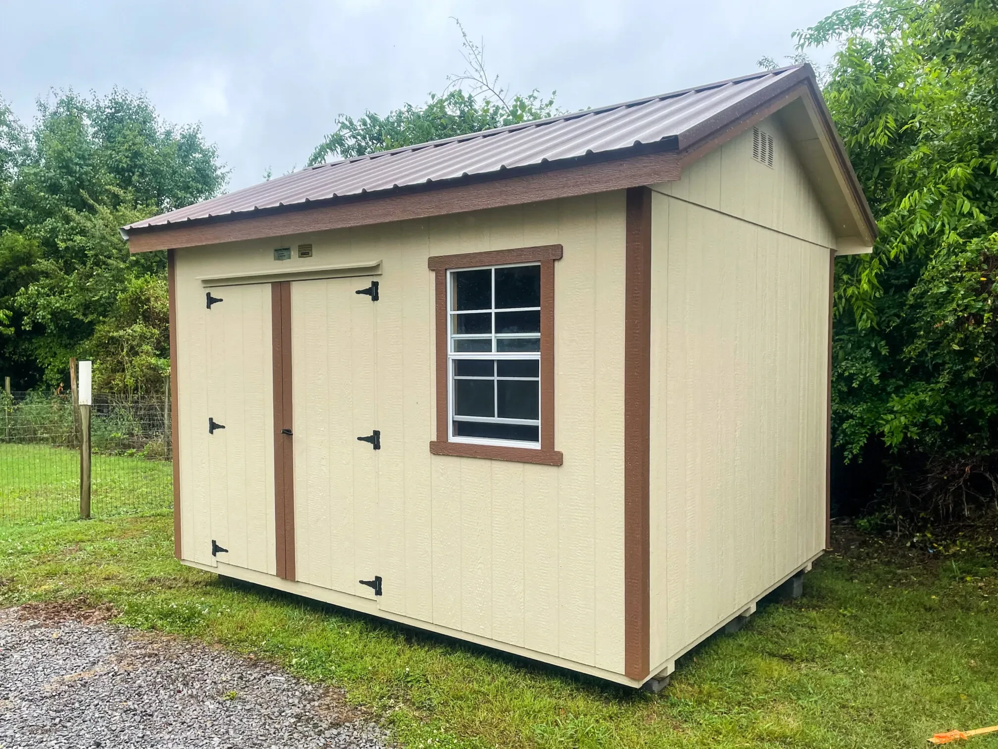 A small tan and brown shed