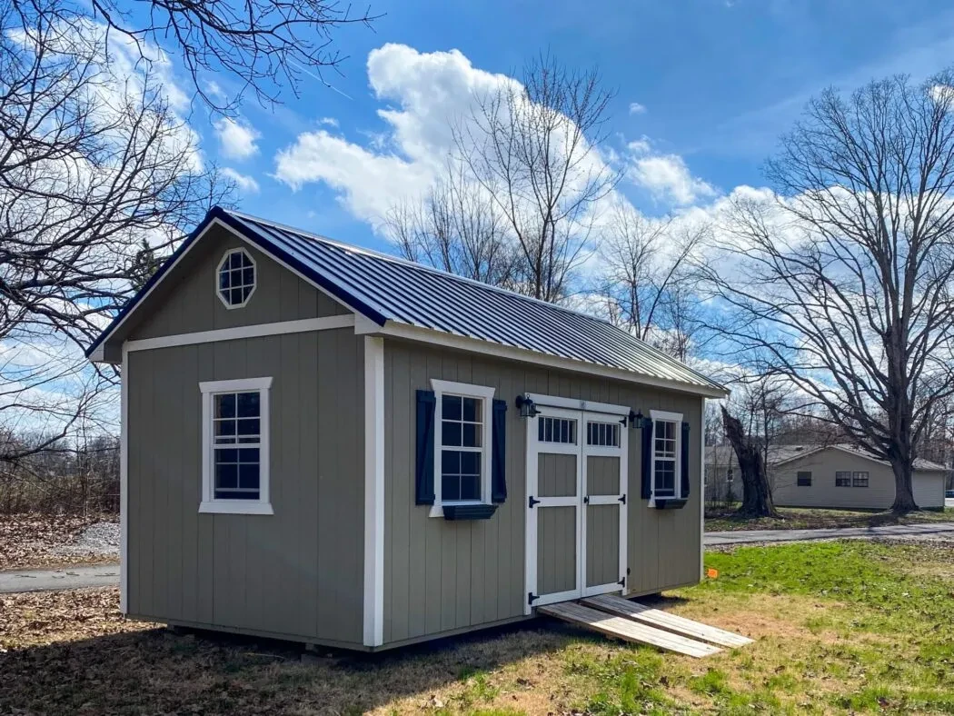 A deluxe wood shed with multiple windows and doors, ramps, and shutters