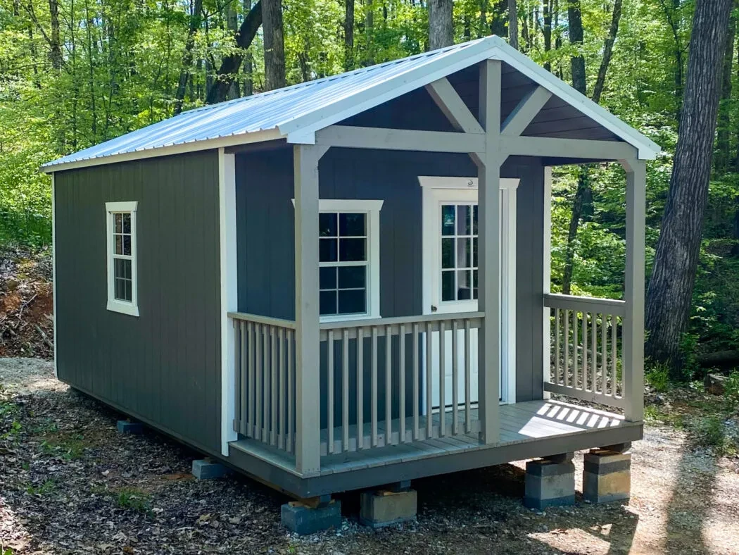 a dark blue shed with a porch on the front
