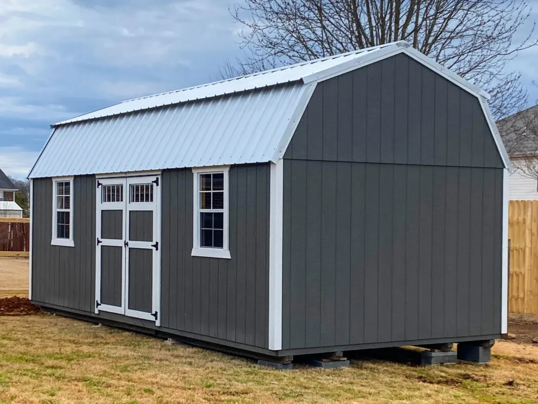 a dark gray lofted shed with white roof and trim