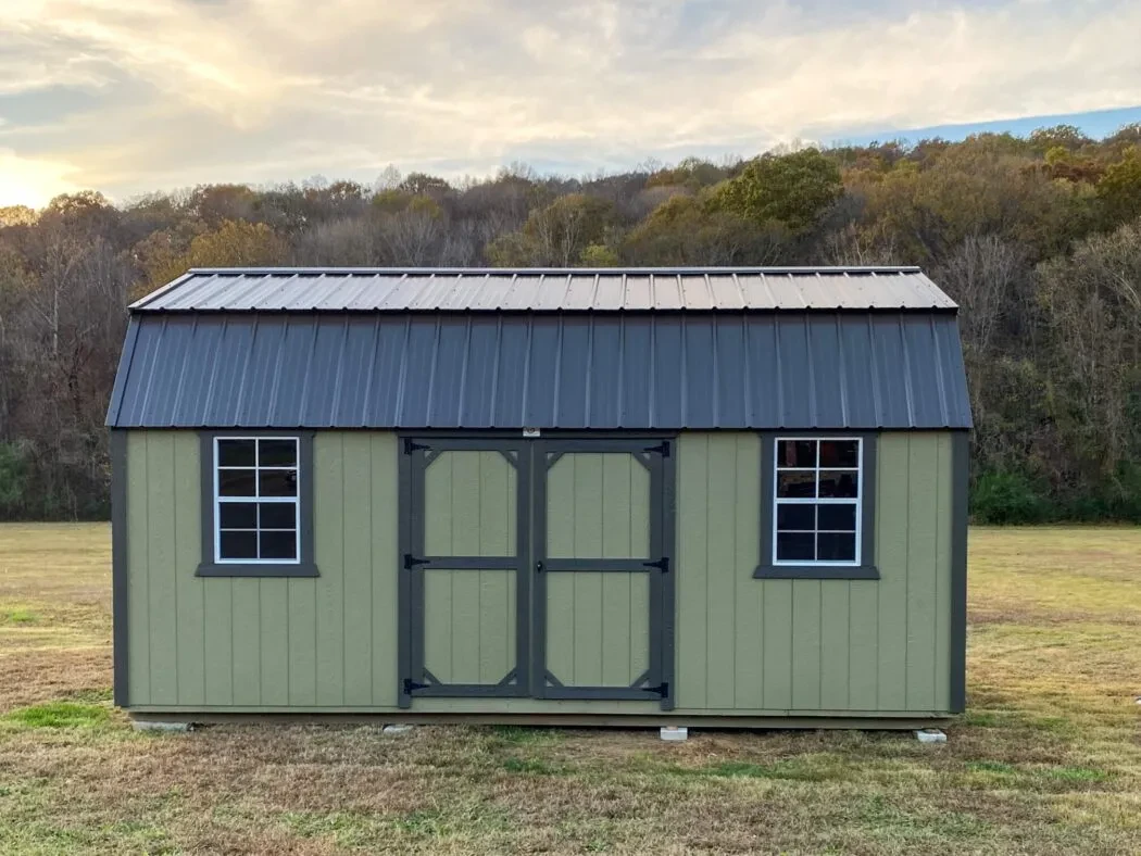 A green and black side lofted shed with double doors and two windows in the shed