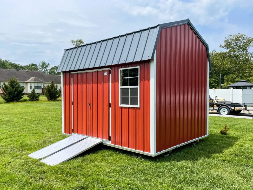 a small red metal shed with ramps at the double doors