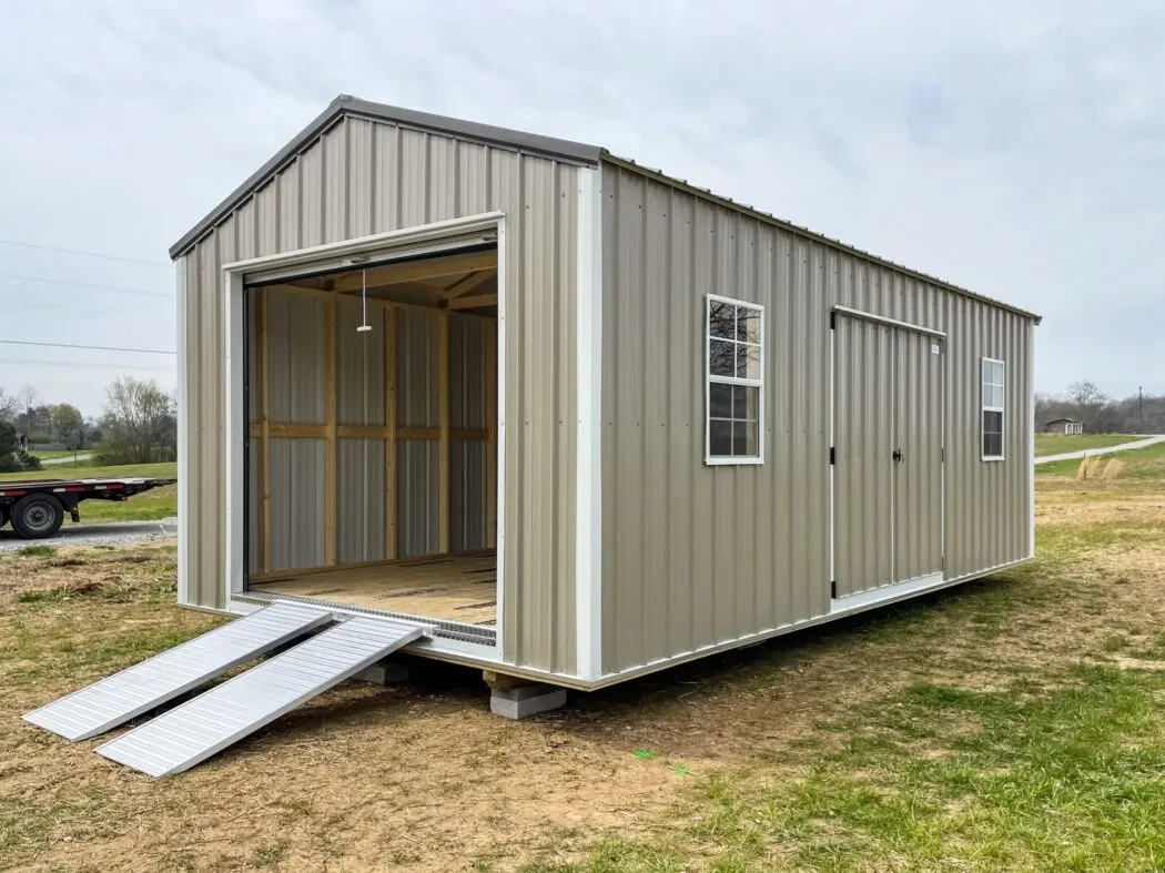 A large garage shed with an open garage door in the end with a ramp
