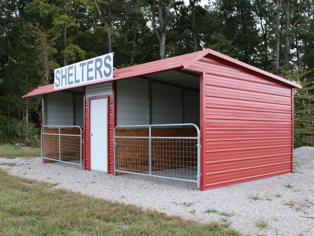 a red animal shelter with two gated stalls and an enclosed tack room area