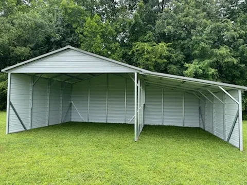 A squared frame carport with an attached lean-to on one side with both sides and the back enclosed