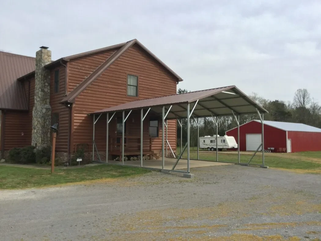 A large open squared frame carport at the end of a house