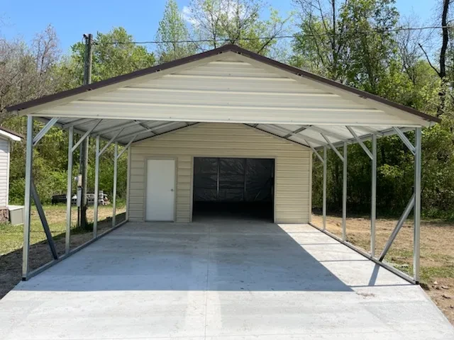 A squared frame carport with an enclosed area in the back with a garage door and a walkin door