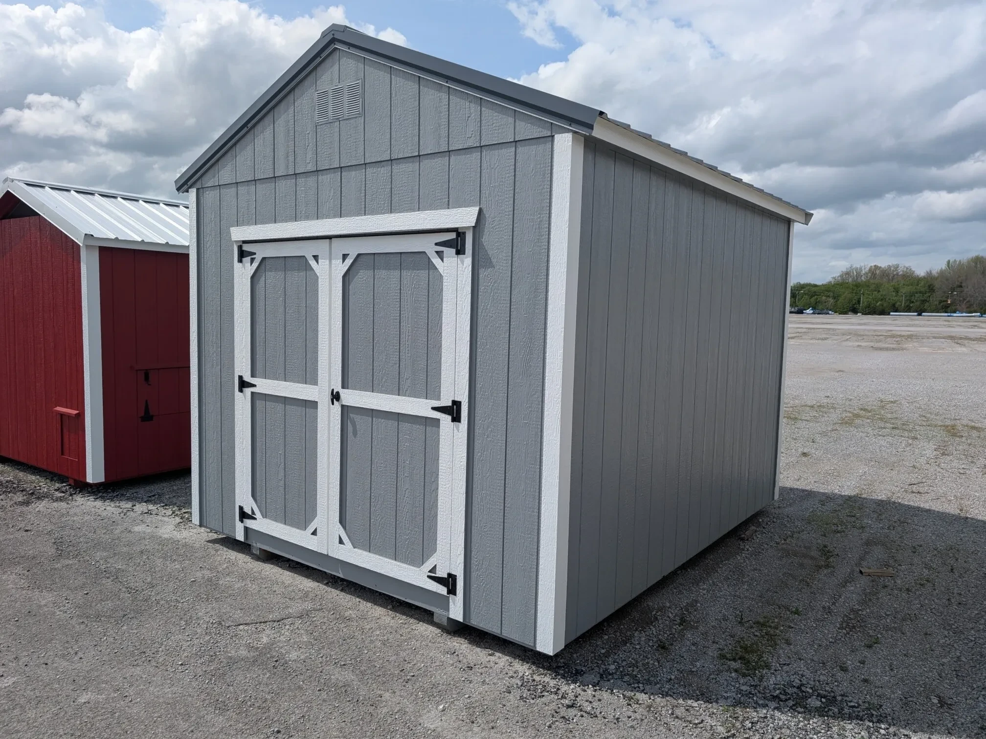 A corner view of a gray wood shed.
