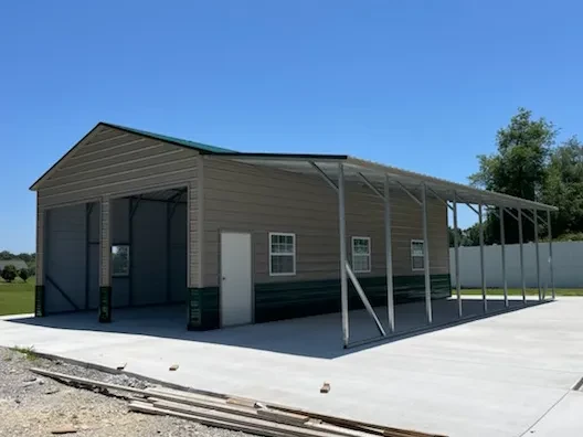 A large enclosed garage with multiple doors and windows and an open lean-to along one side