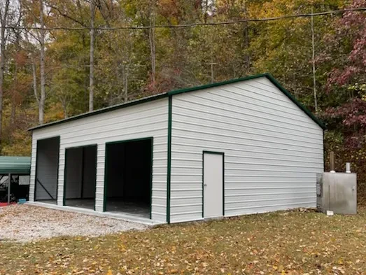 A large enclosed garage with three garage doors of varying sizes in the front