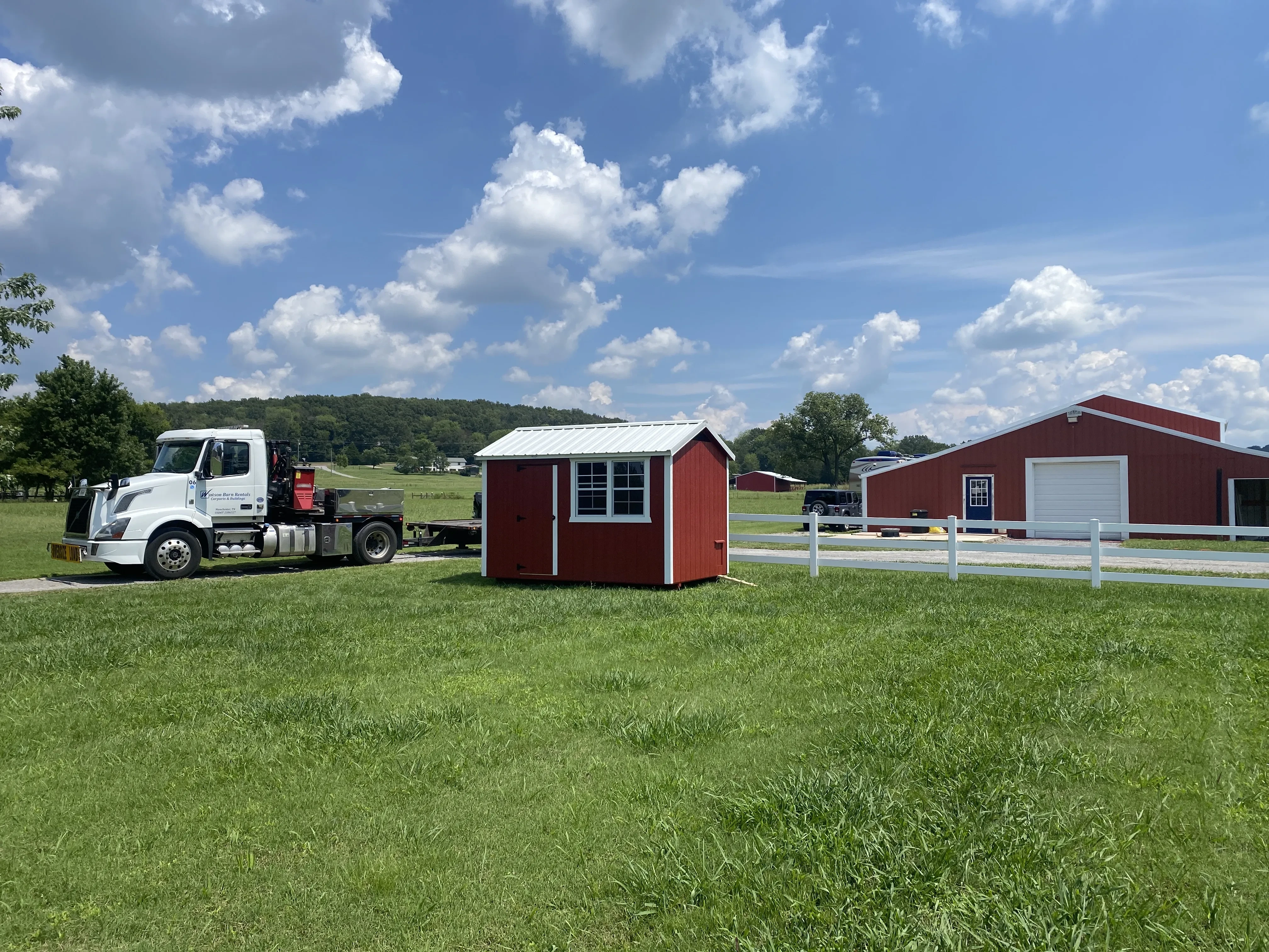 Red chicken coop in a green field