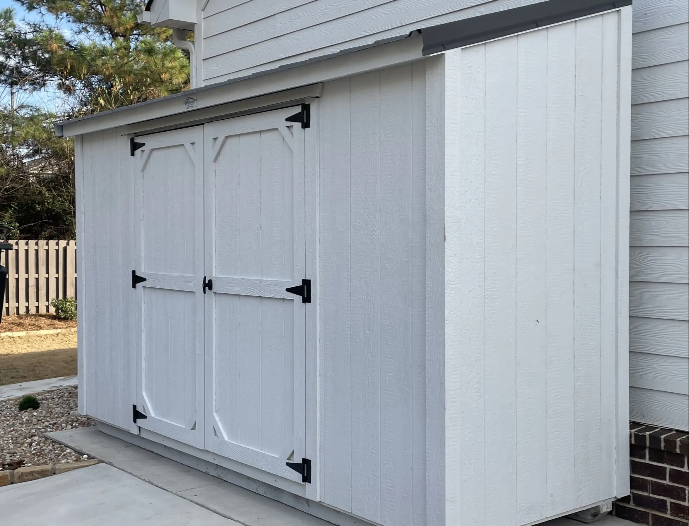 White lean-to shed up against the side of a house