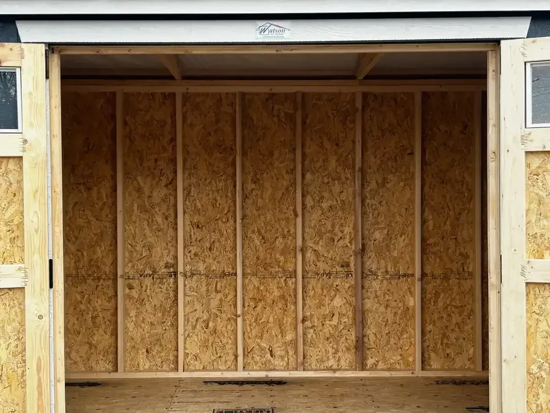 looking inside a wood garden shed through the double doors which are wide open