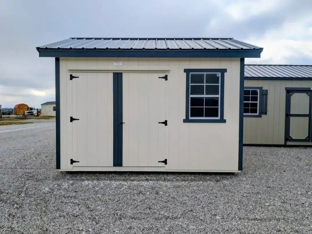 the front view of a wood garden shed. It has double doors and a roof overhang on all sides. It has one window