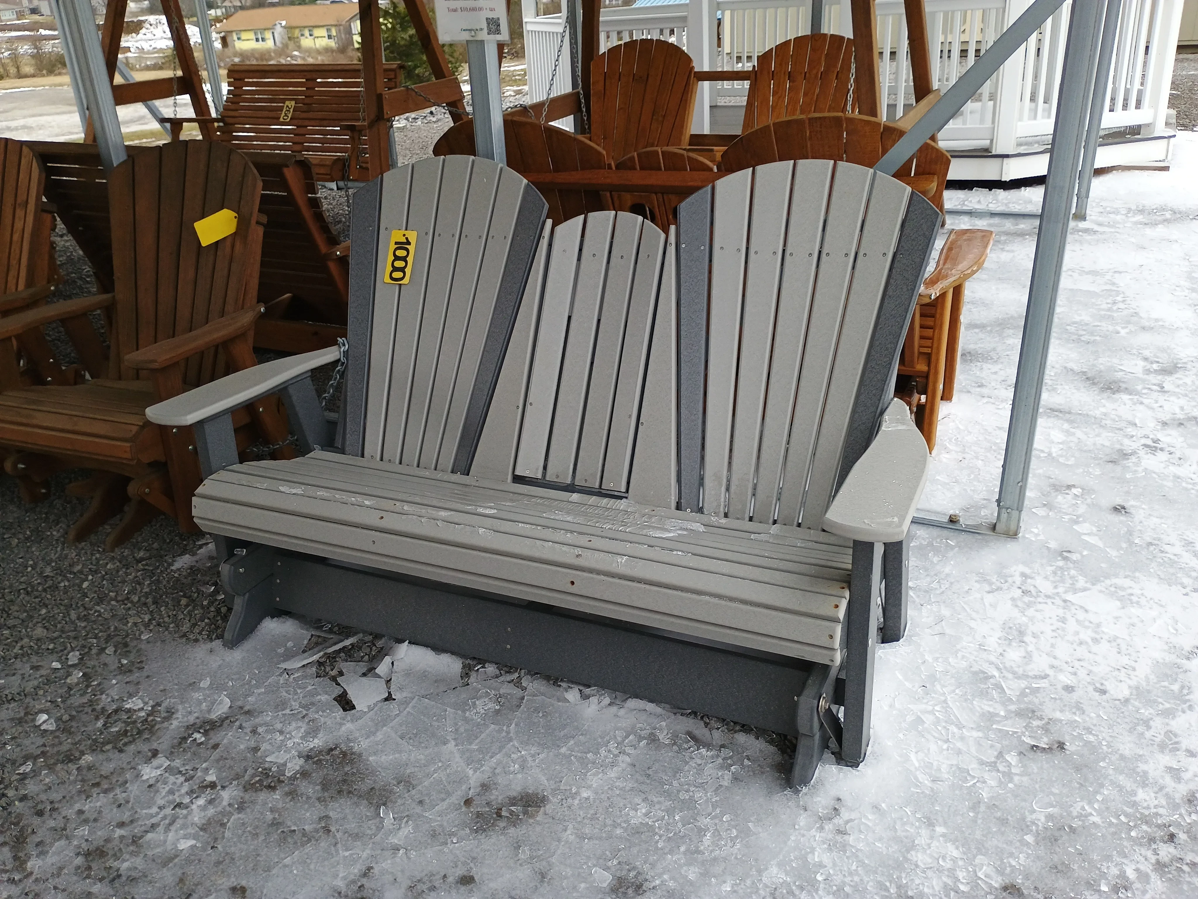 a polywood bench with a center console in the up position. There is ice on the ground.