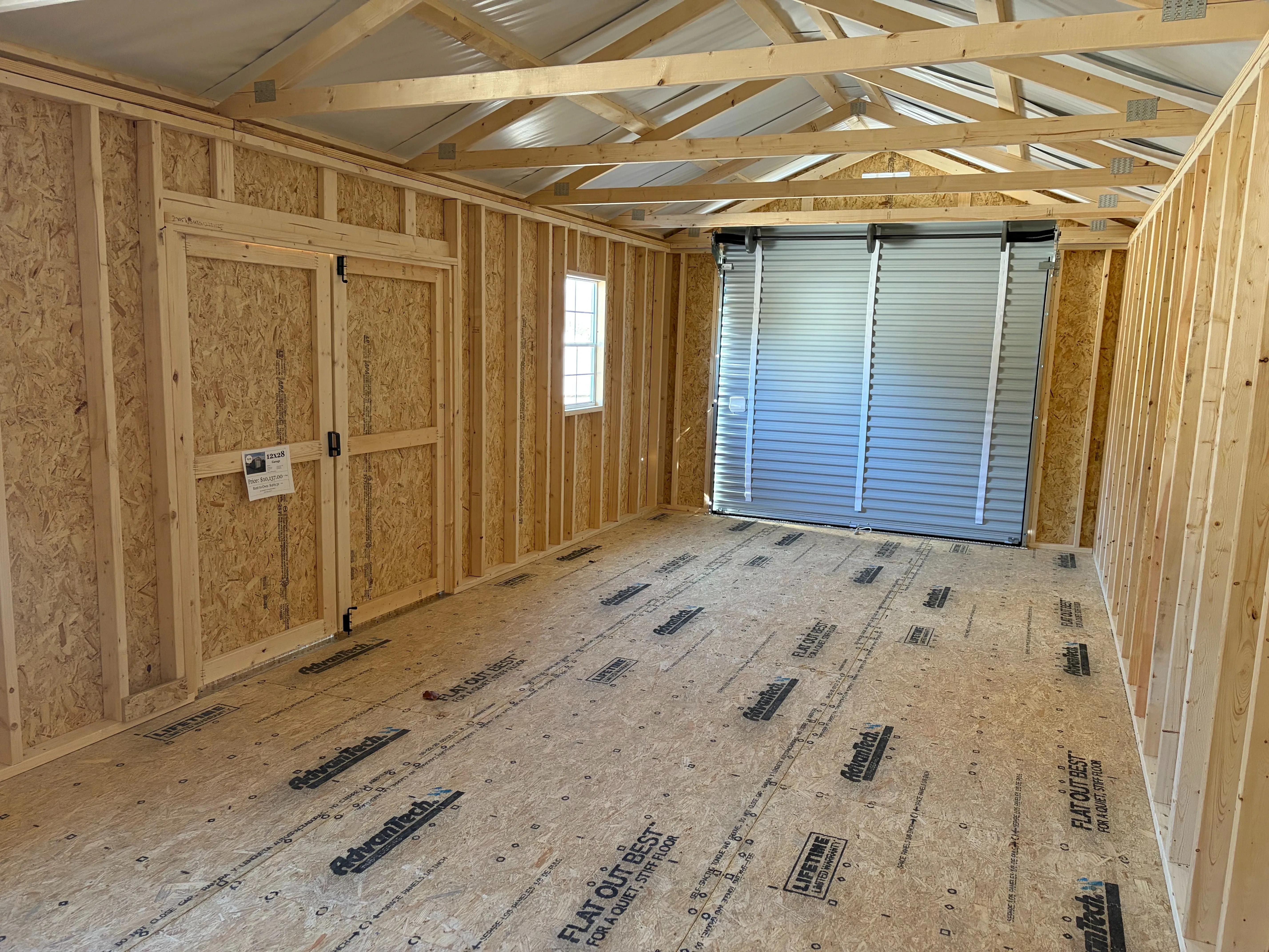 the inside a large garage shed with multiple windows and double doors that are closed