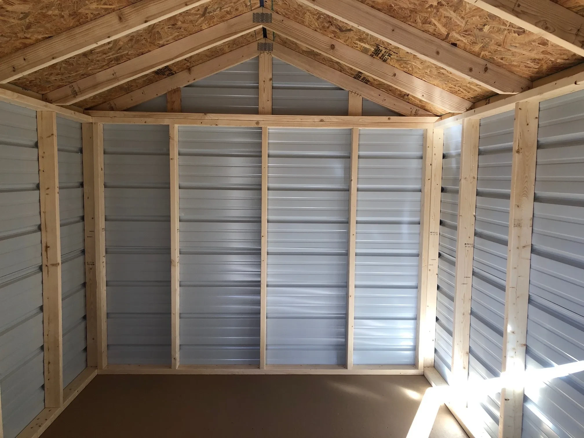 inside of a metal shed showing the floor and framing
