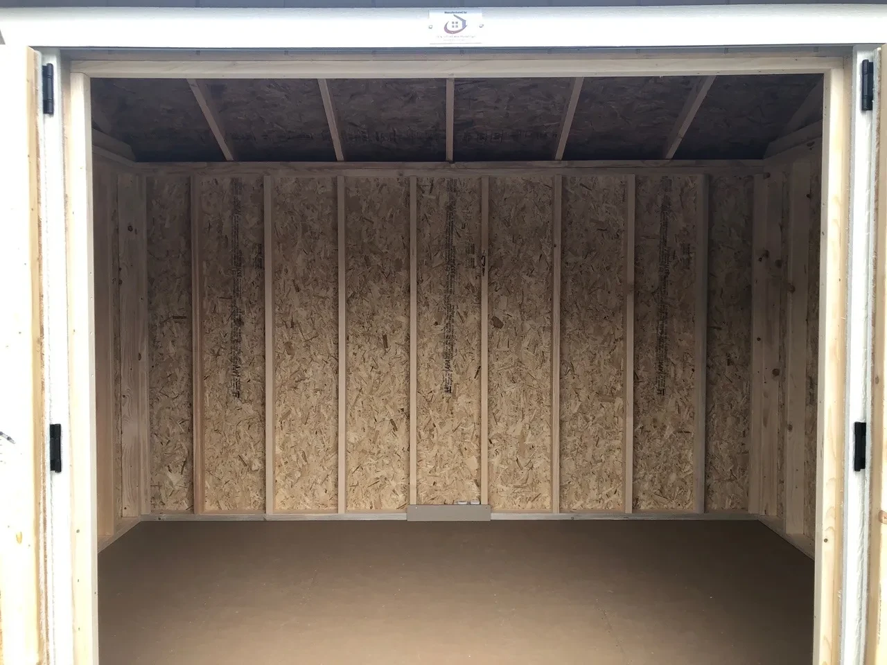 inside of wood shed showing the floor and framing
