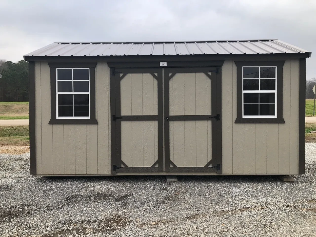small clay wood shed showing double doors and 2 windows