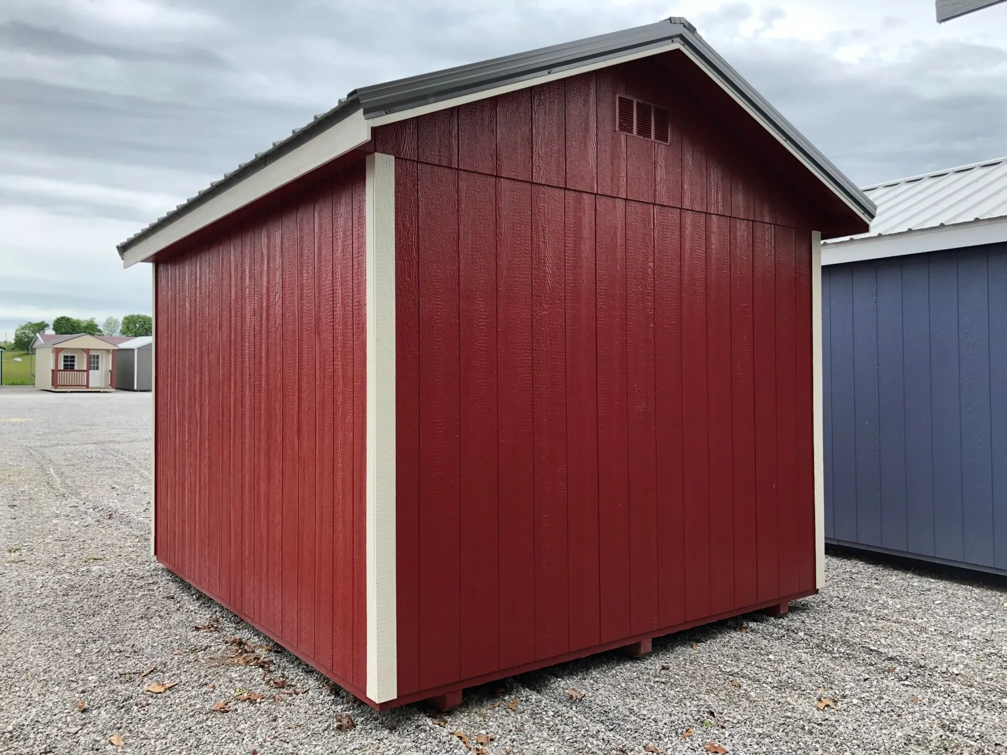 the back side of a red shed with white trim