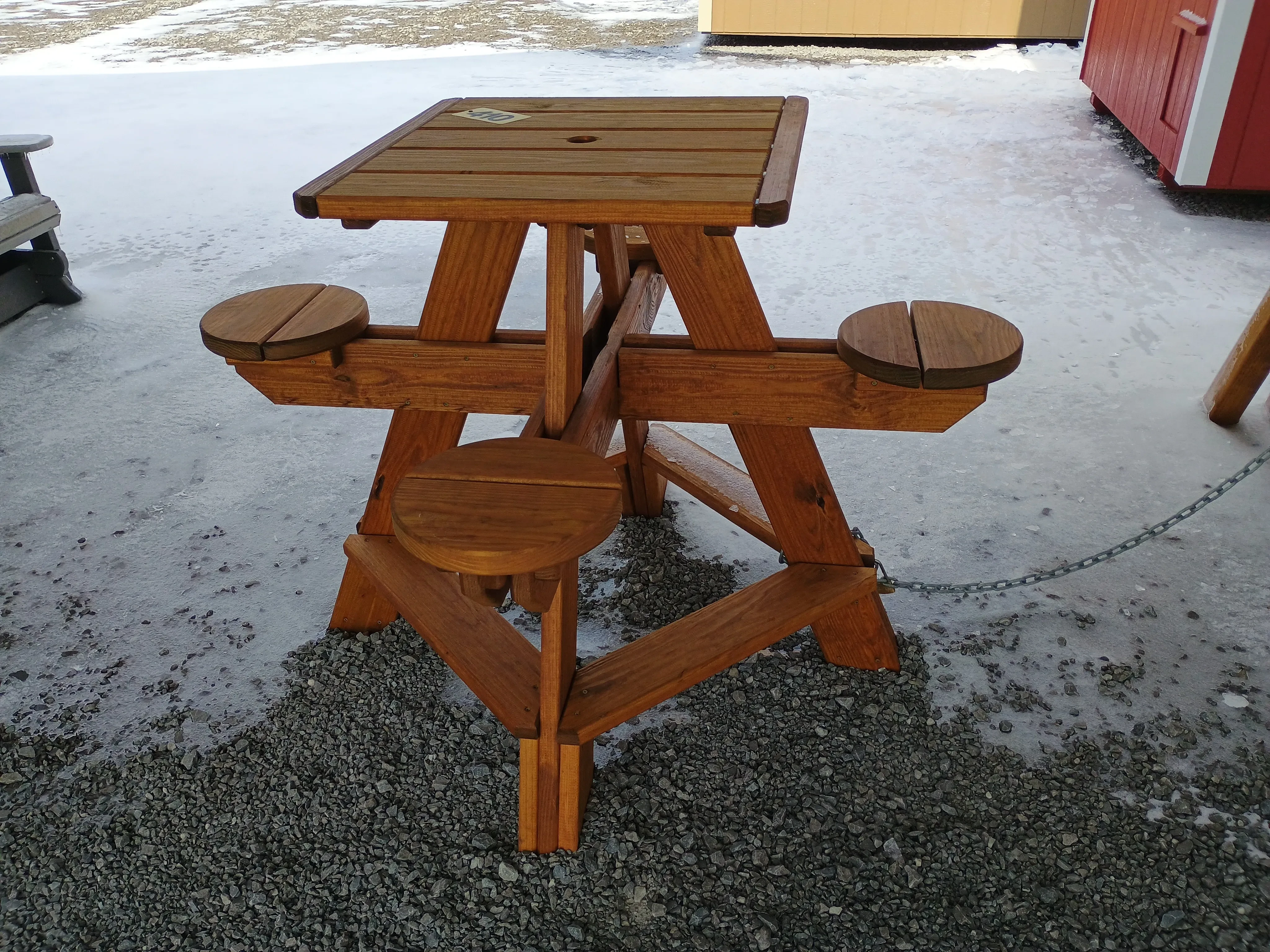 a table with horizontal planks, it also has four circular seats