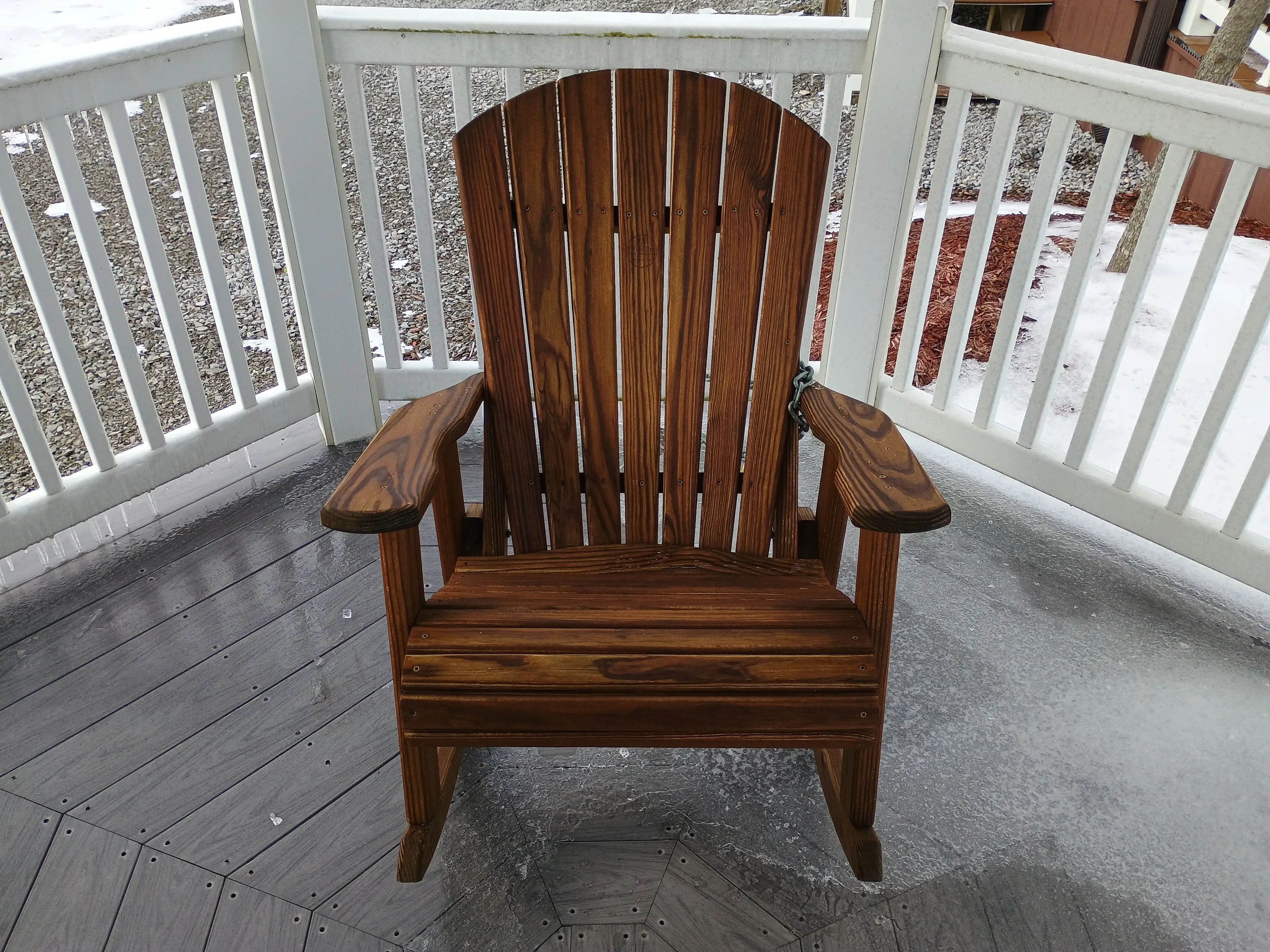 the front view of a wood rocking chair. It has arm rests