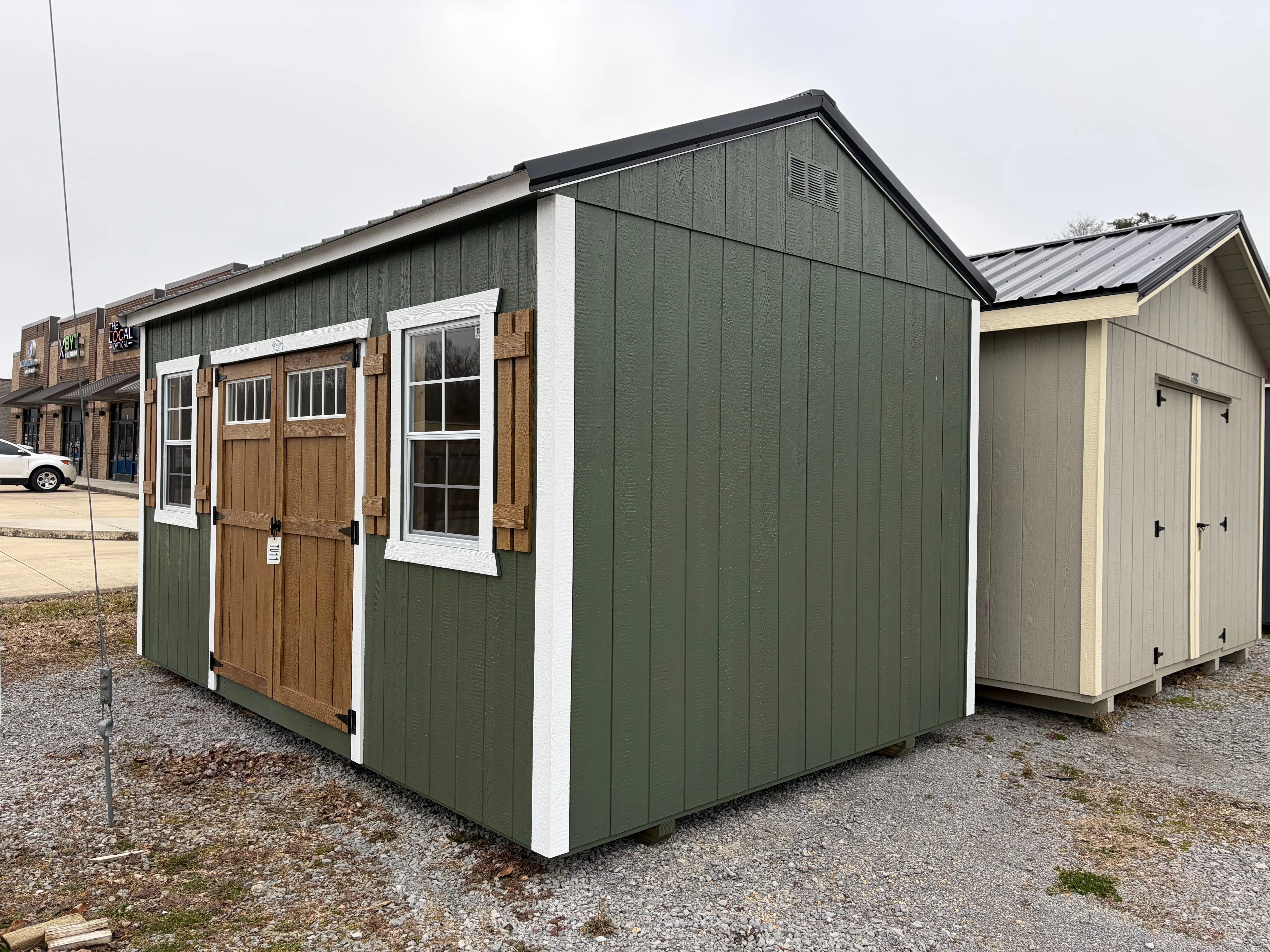 outside of the 10x16 garden shed showing the stained double door and shutters