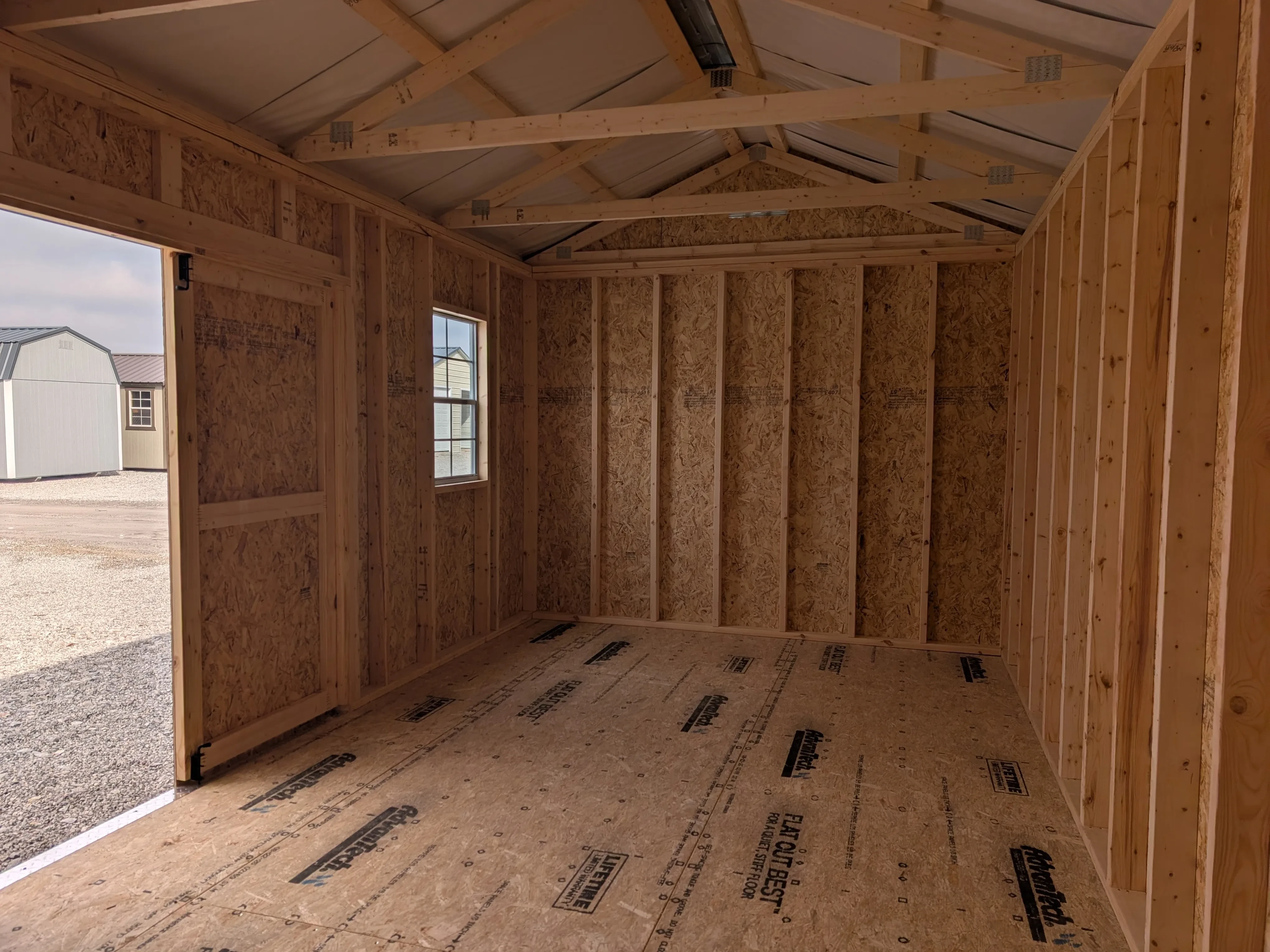 inside a wood garden shed looking at the left wall. There is a vent up towards the ceiling.
