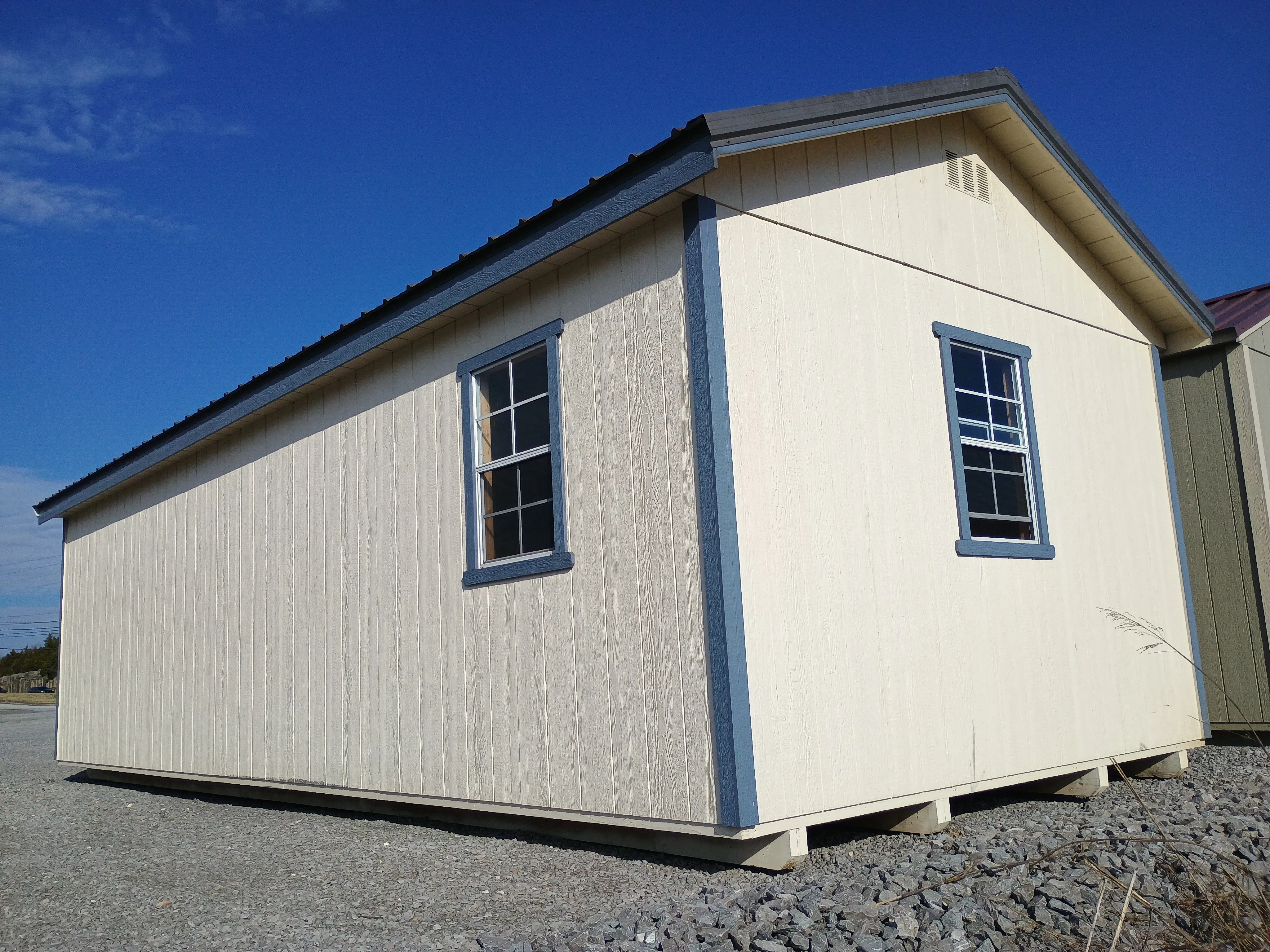 exterior rear side view of 12x28 premium wood utility REPO shed, showing rear and side windows