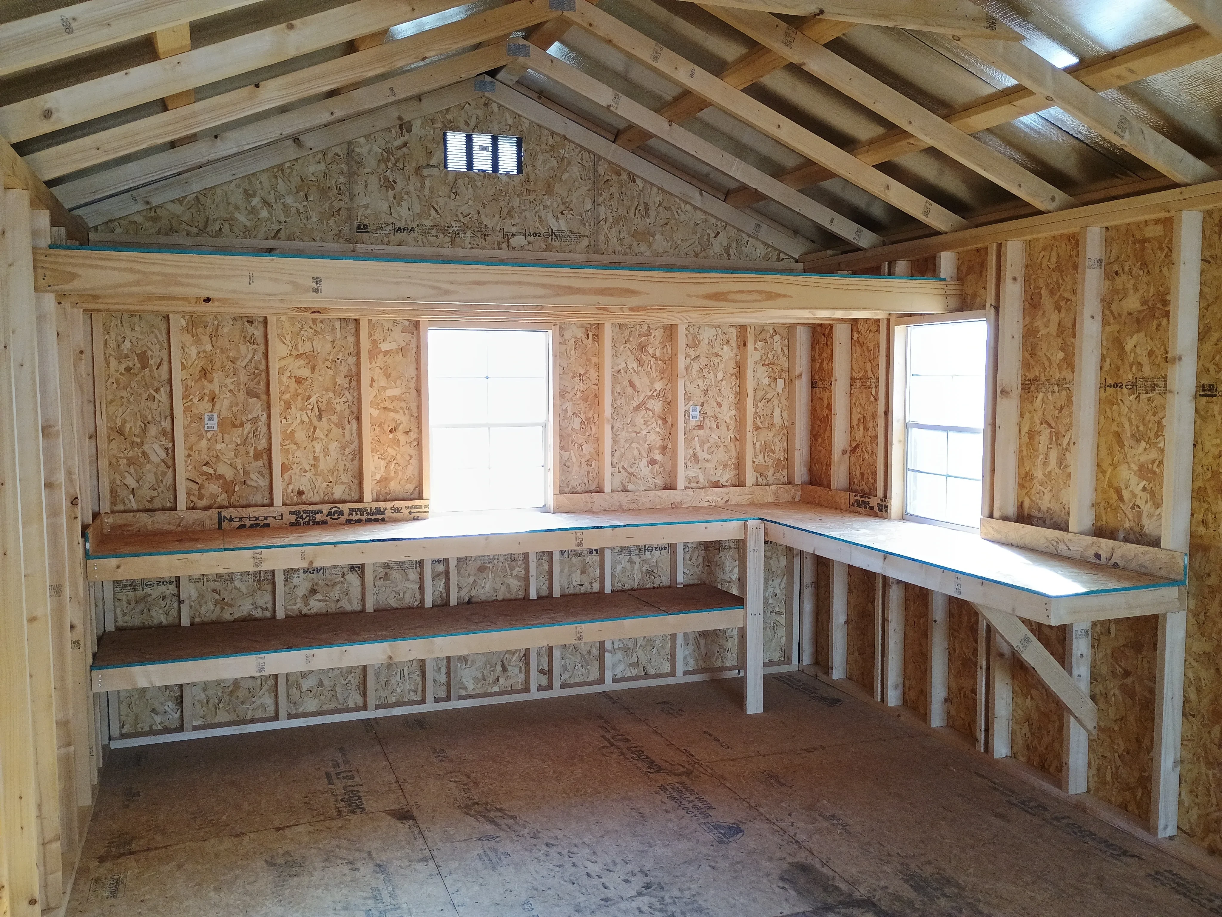 interior of 12x28 premium wood utility REPO shed, focusing on 2 windows, loft, double shelves, and workbench