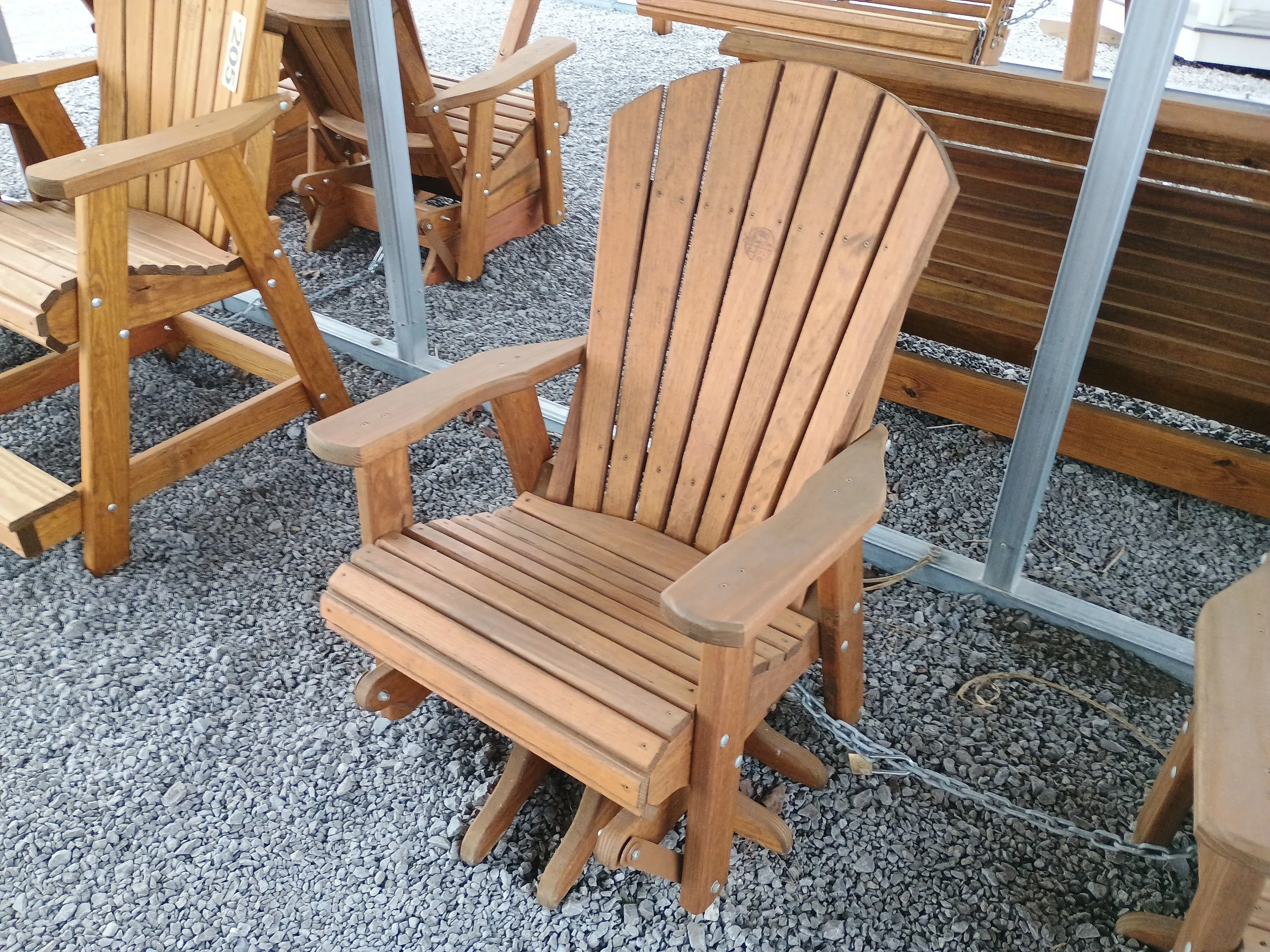 a wood stained and sealed chair that can swivel all the way around and glide back and forth. It is chained up