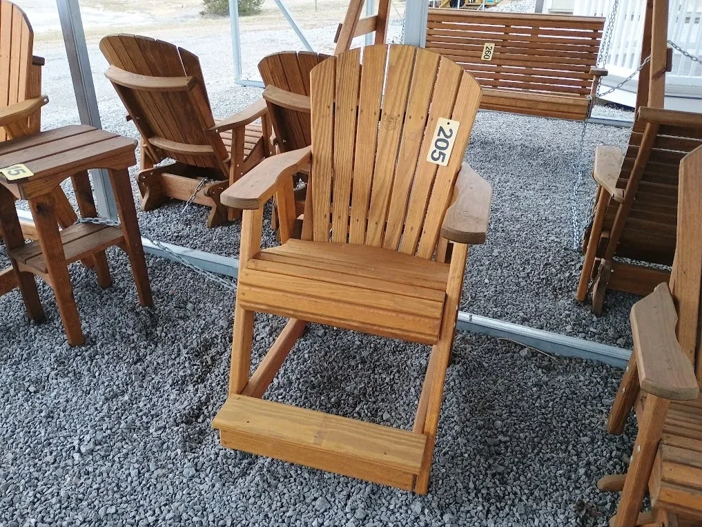 a wood stained and sealed chair sitting next to other furniture. It has armrests and footrests