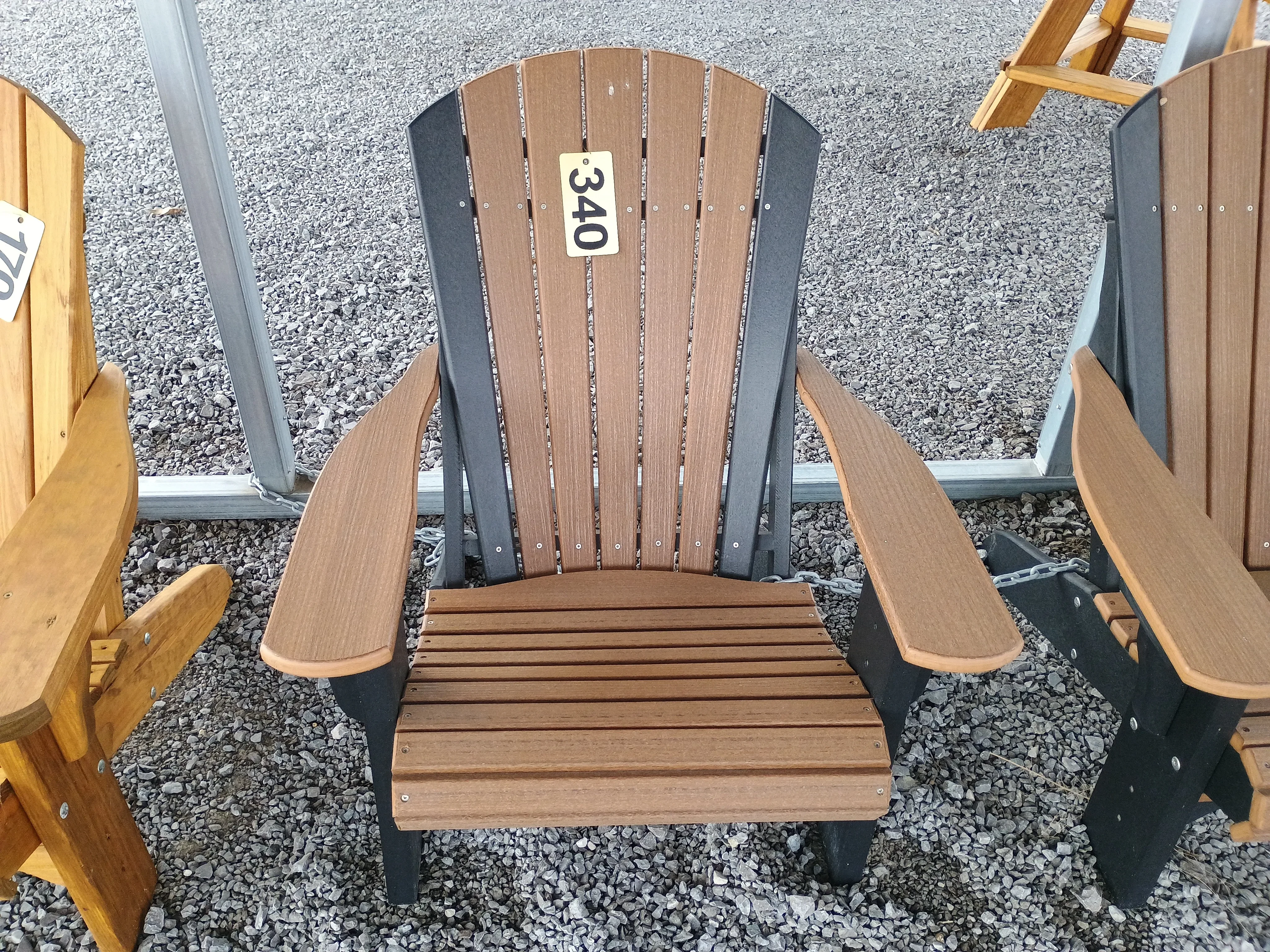 a brown and black chair sitting in the gravel. It has a yellow price tag on it that shows "340"