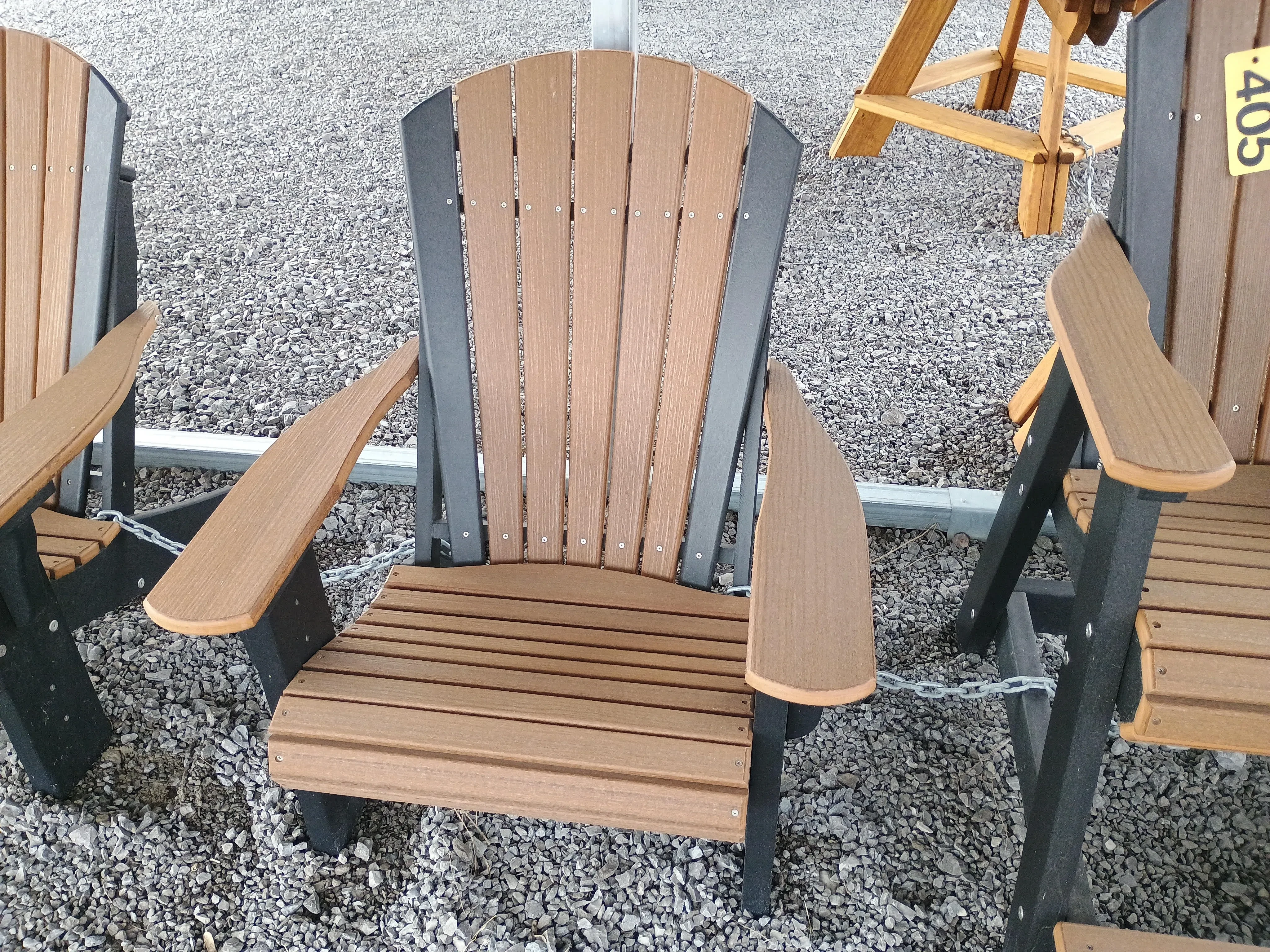 a brown and black chair chained up to other chairs nearby. It's sitting in the gravel