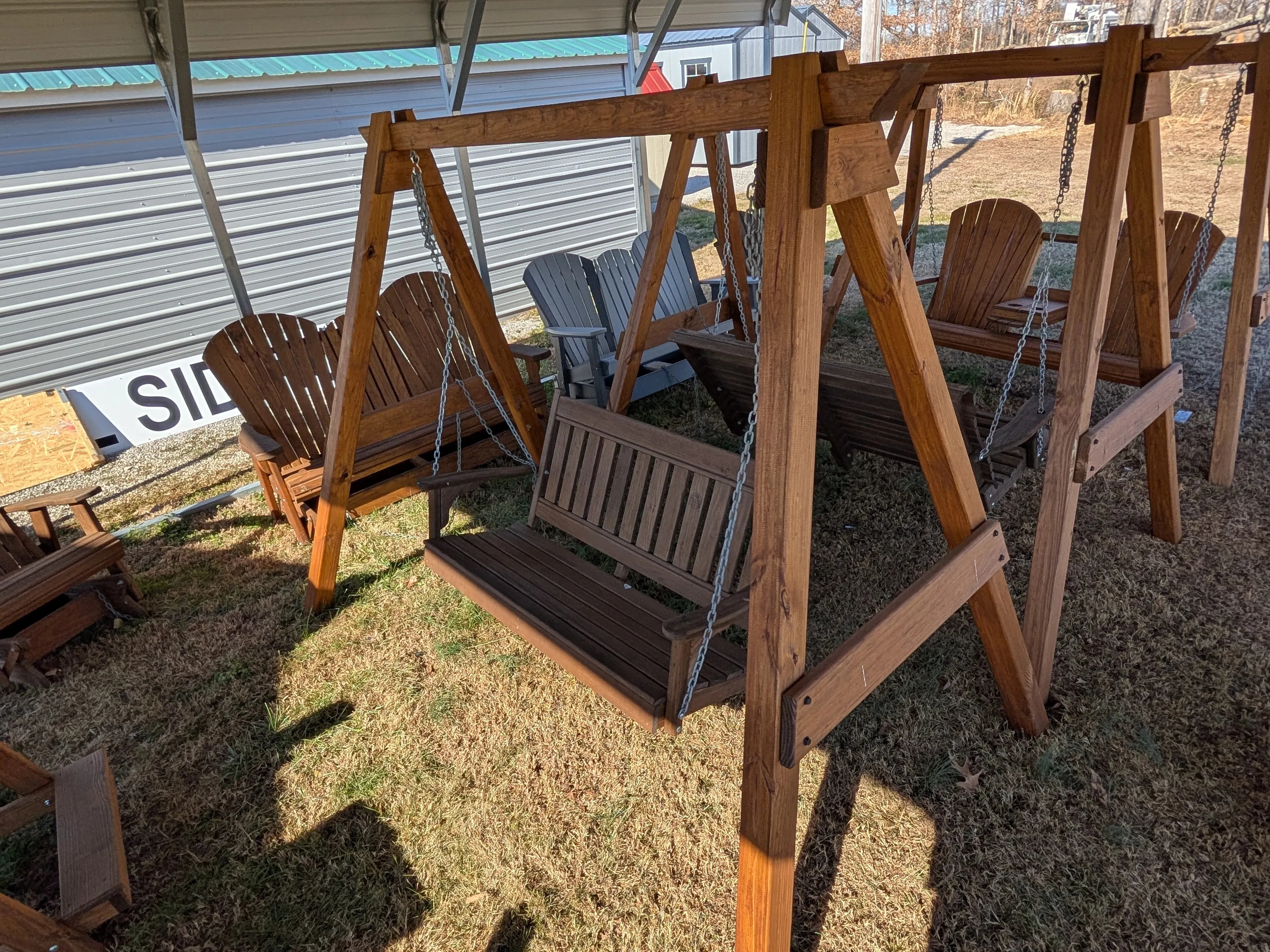 a wood a-frame structure holding up a garden bench in the grass