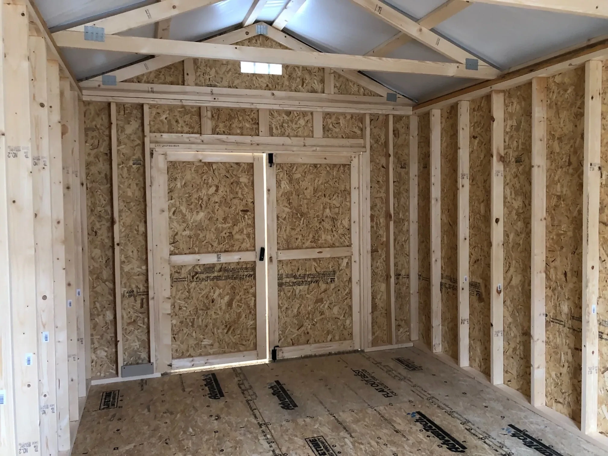 The inside of a wood shed showing the double doors closed