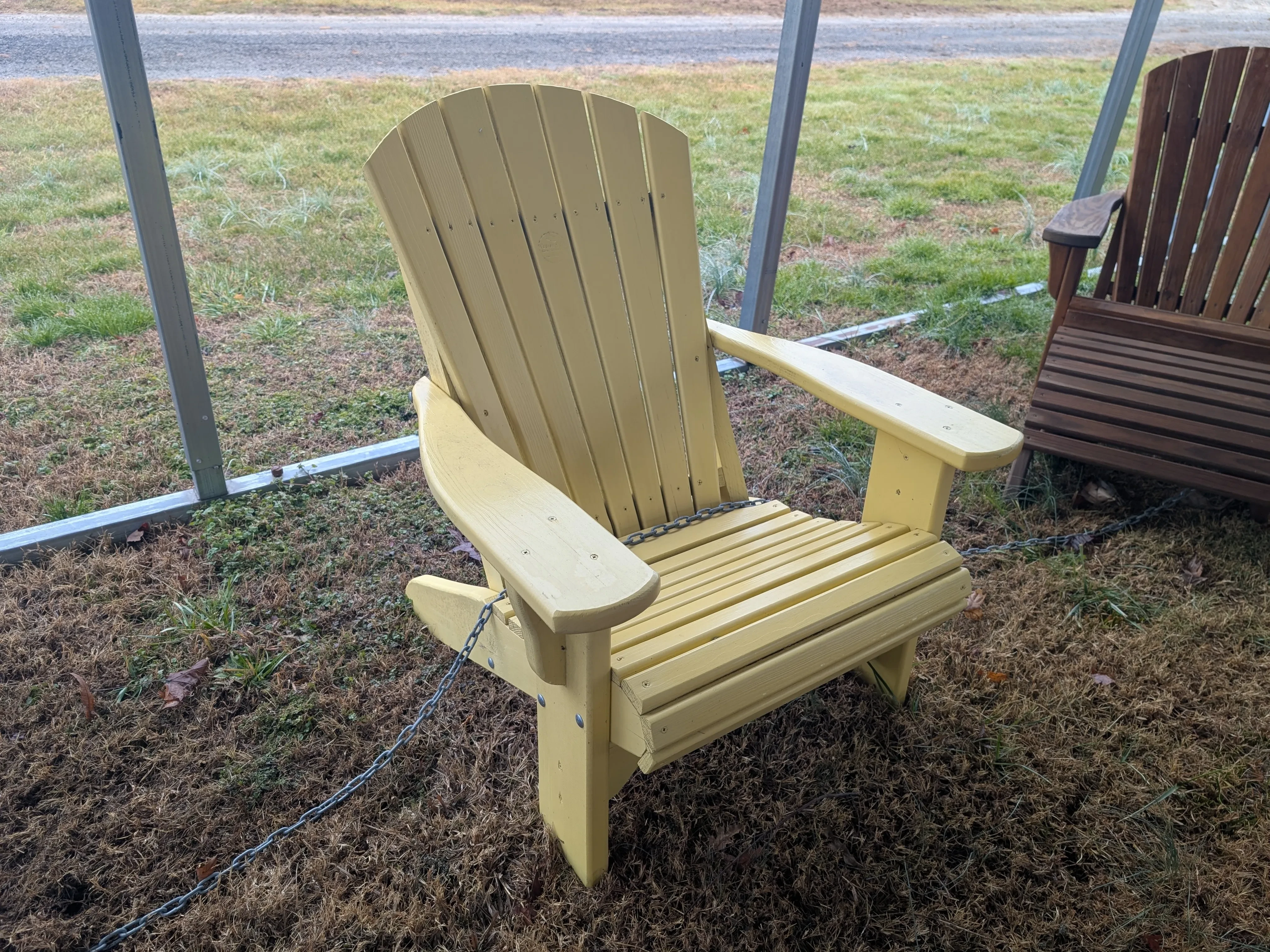 a yellow chair sitting in the grass next to other furniture