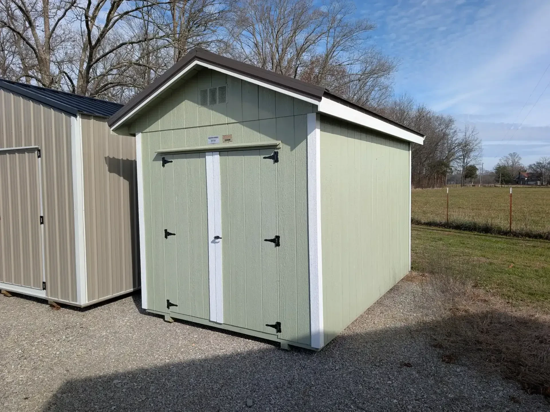 light green shed with double doors.