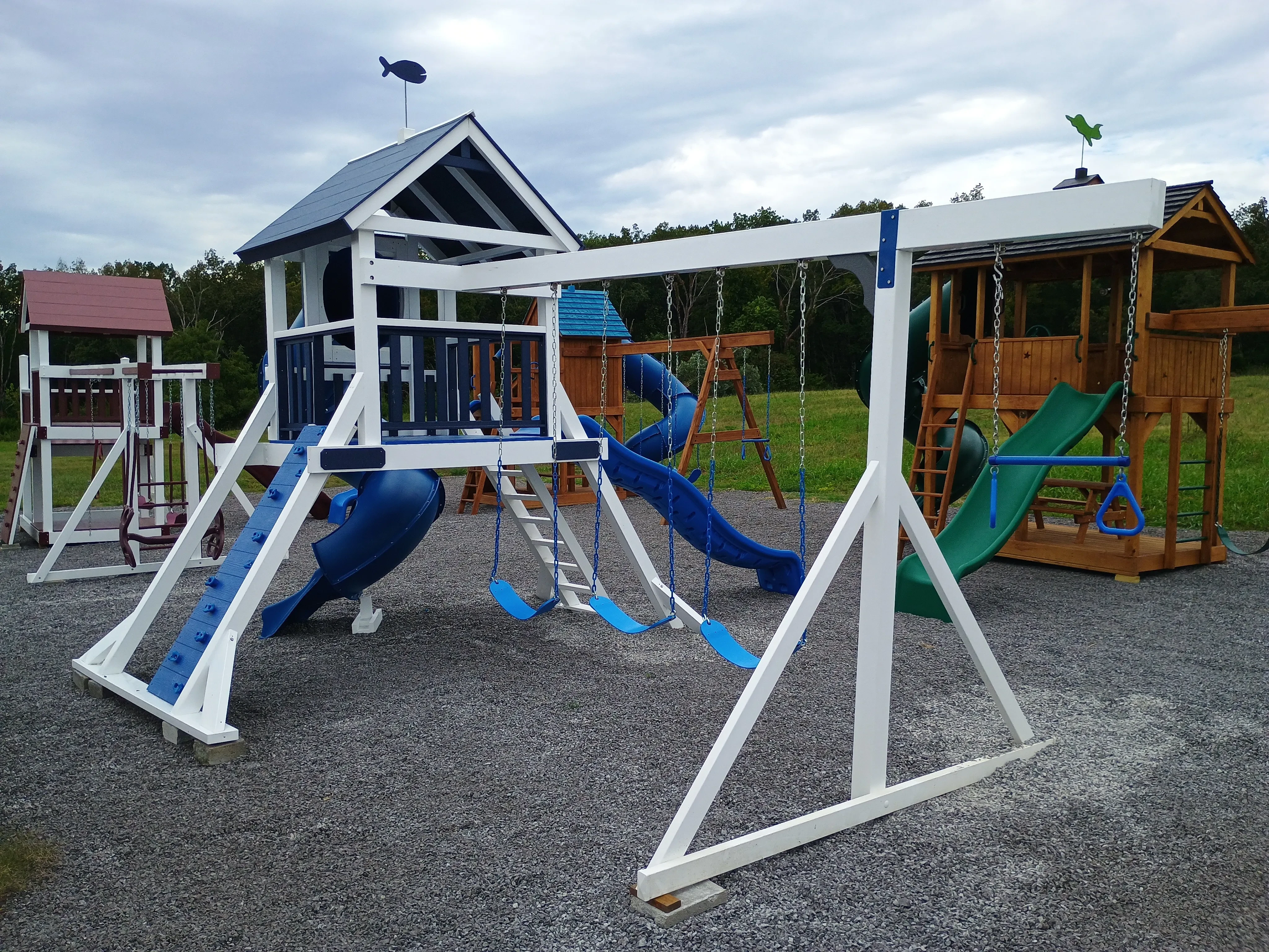 a white vinyl playset with blue slides and a blue roof