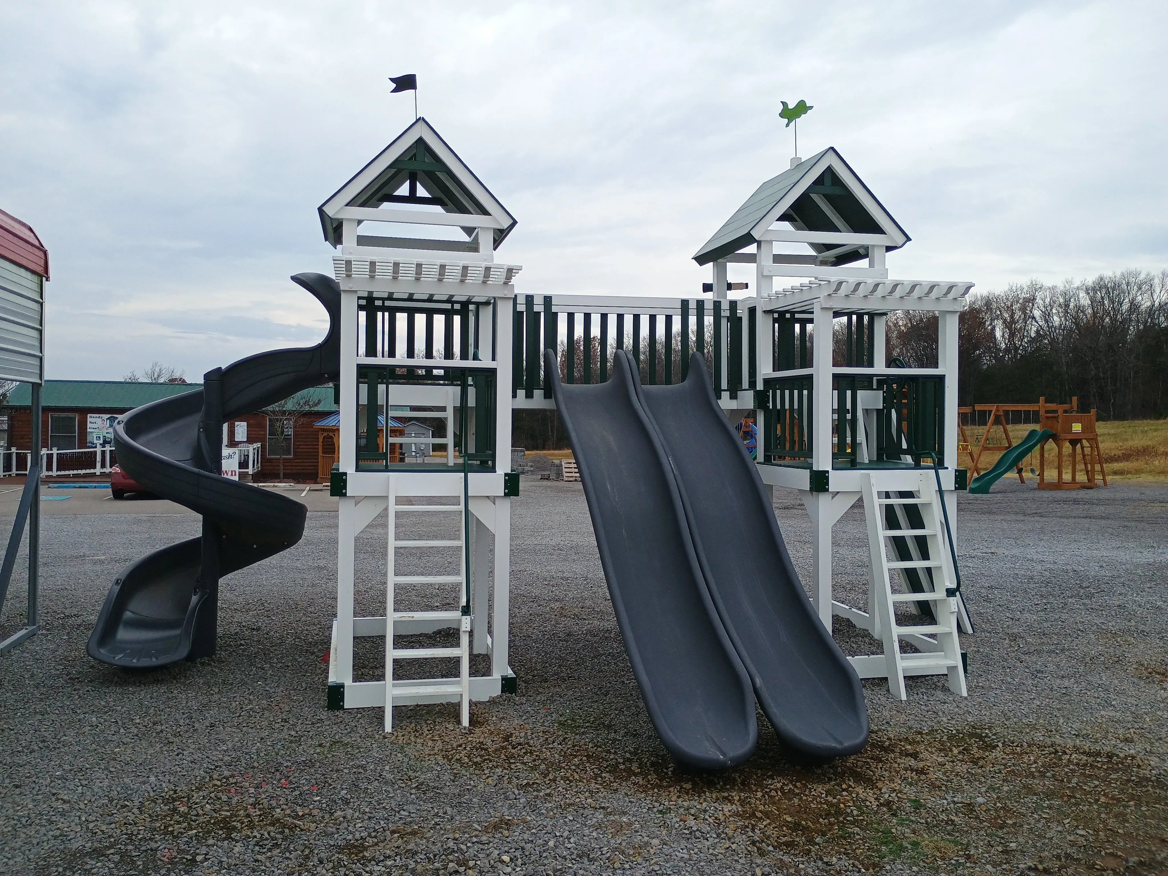 a large double playset that is white vinyl. It has a double slide and a corkscrew slide with many additional options