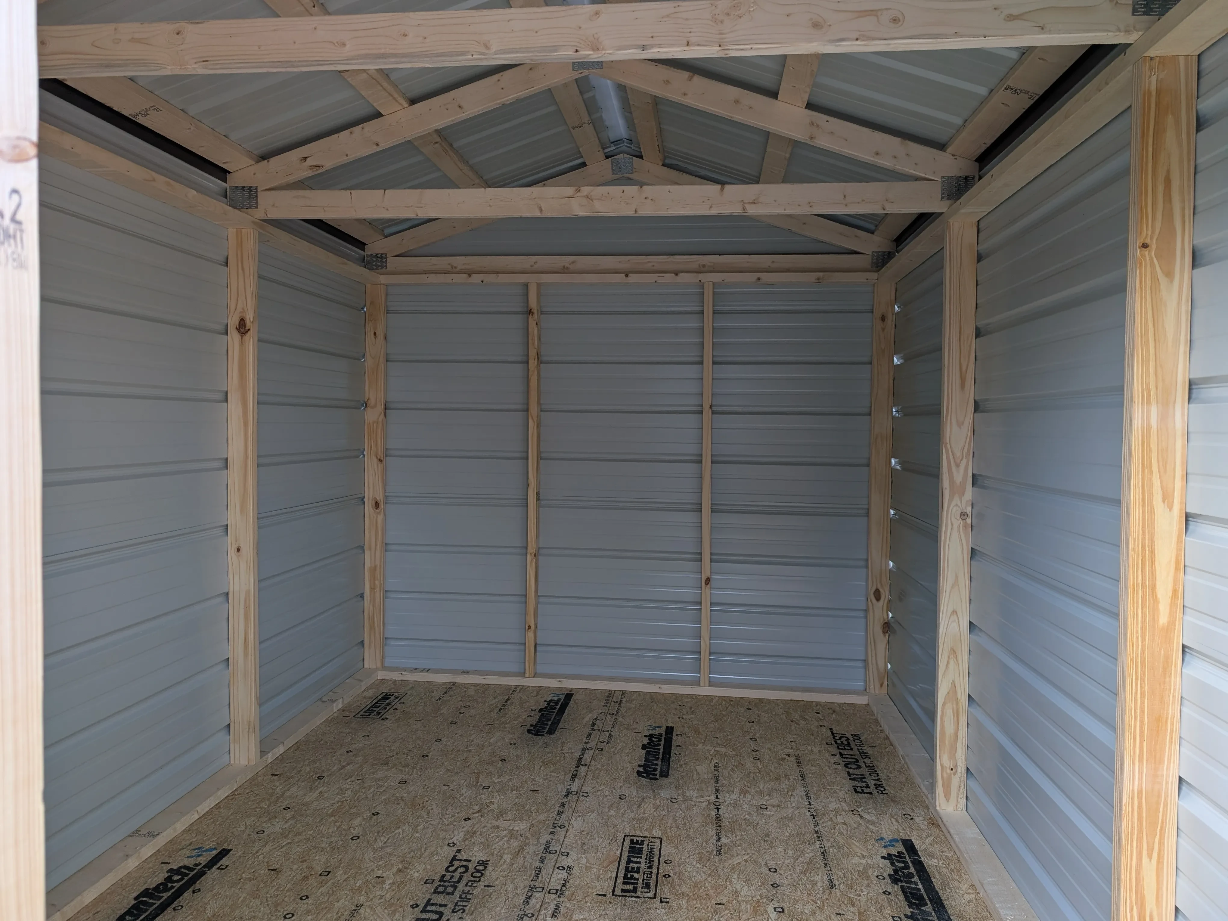inside a metal utility shed. It has lumber framing and trusses visible