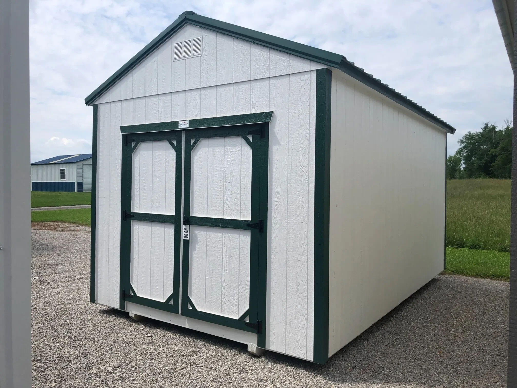 the front right view of a white shed with green trim