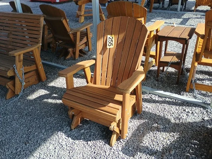 a nicely stained and sealed wood chair sitting under a carport in the gravel
