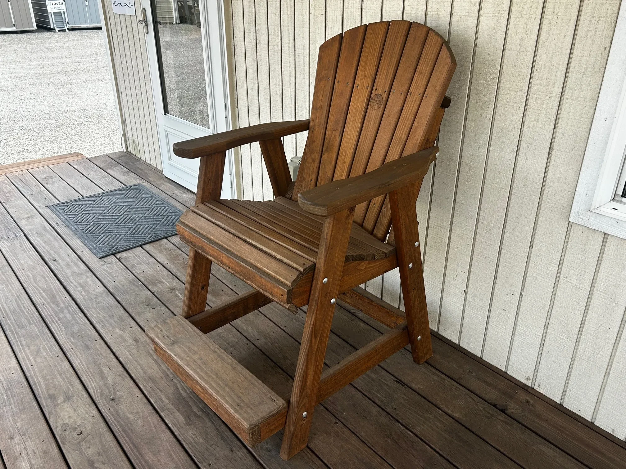 a chair sitting on a wood porch. The chair is nicely stained and sealed to last a long time