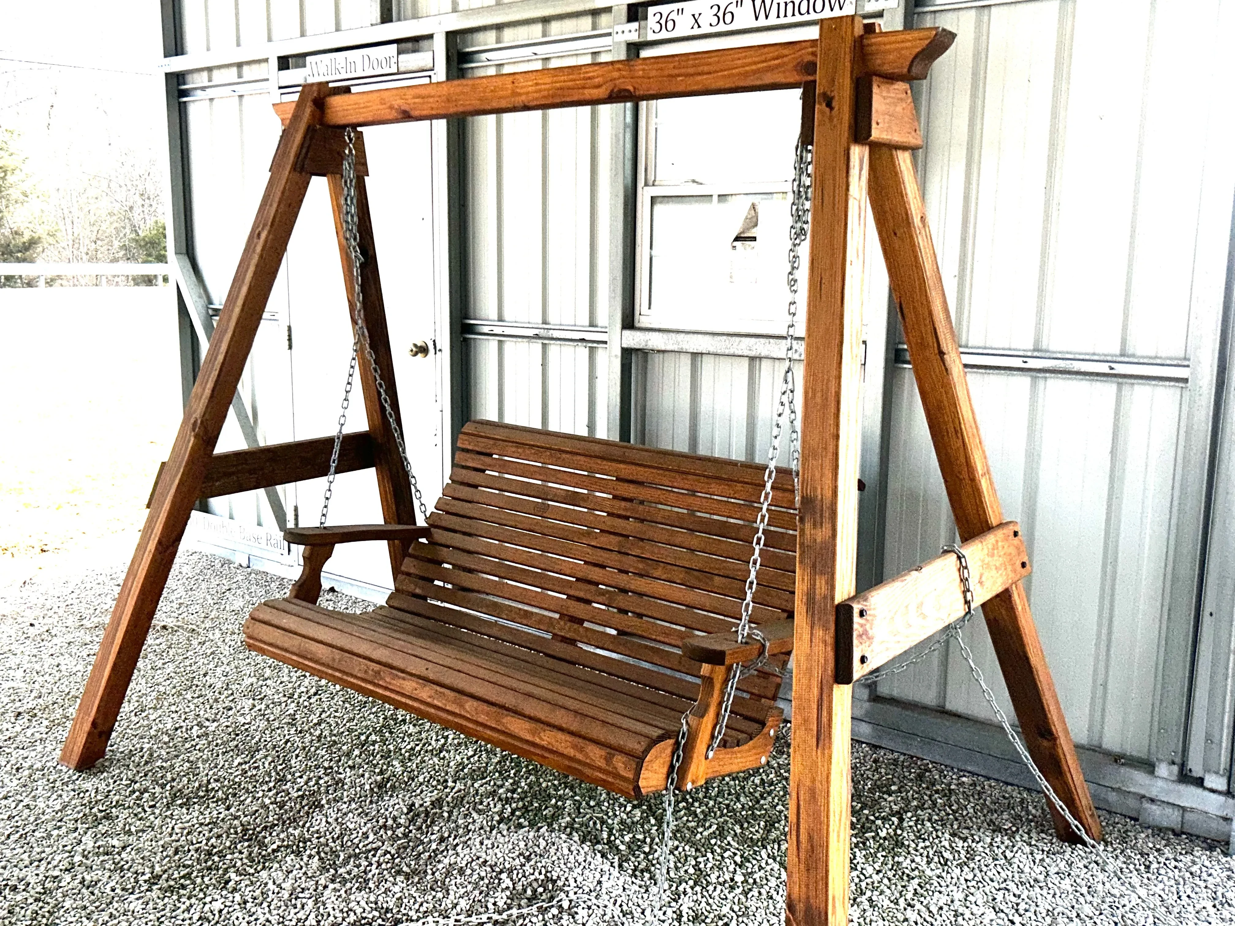 a wooden a-frame structure holding up a wooden bench in the gravel. It is professionally stained and sealed